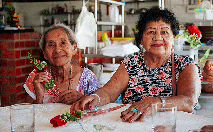 Madres adultas mayores celebrando con música y regalos